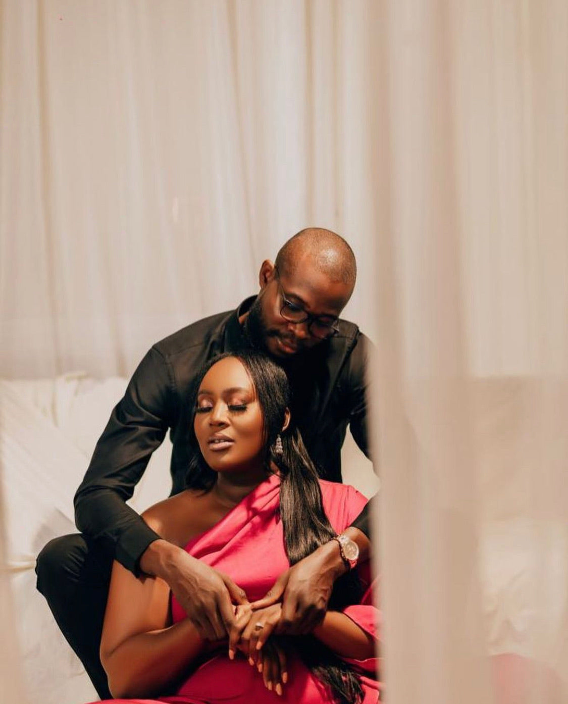 Romantic couple with woman in pink dress and man in black shirt, intimate indoor setting